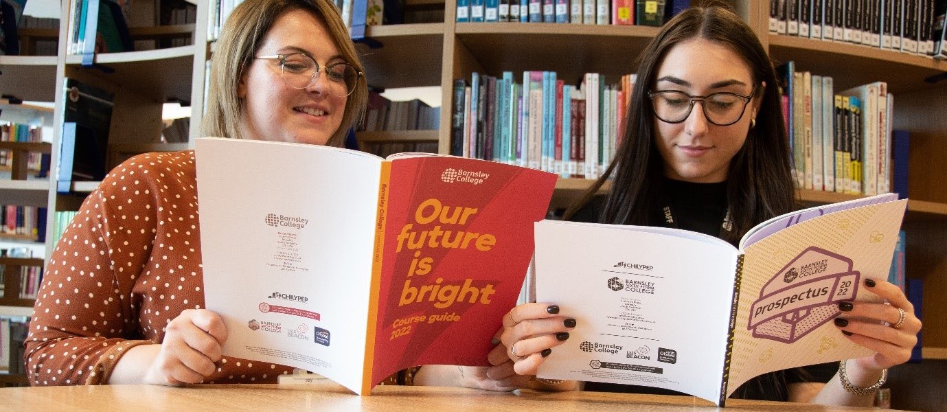 Tanya Searing and Harriet Rowe reading Barnsley College and Barnsley Sixth Form College course guides.