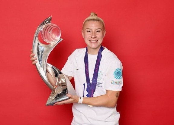 person smiling holding trophy