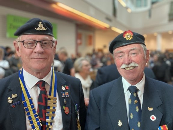 two war veterans smiling with medals and beret on