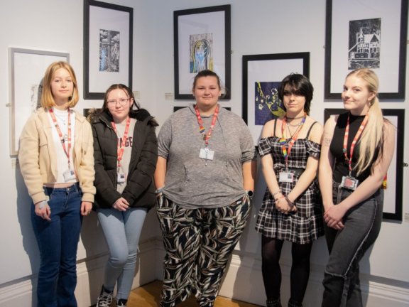 Five Barnsley College students stood in front of their artwork.