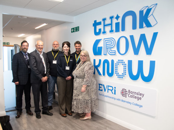 David Akeroyd, Simon Perryman and Helen Weatherston standing with EVRI team in front of EVRI Academy
