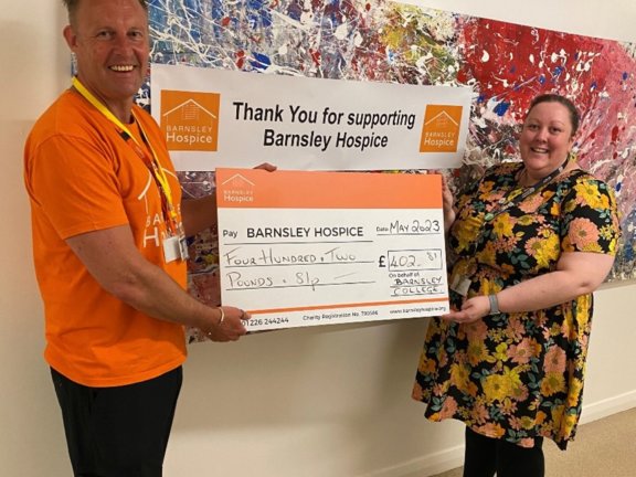 Barnsley College Tutorial Team Leader Vicky Kenny handing over College’s donation to Simon Atkinson from Barnsley Hospice