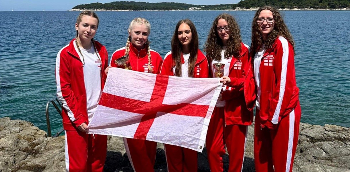 Lucie Roberts, Lucy Frudd, Elisia McCaslin, Ella Tingle and Chloe Tingle holding an England flag in Croatia.