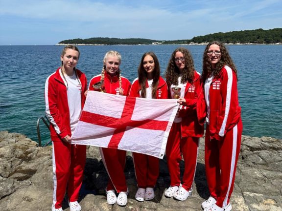 Lucie Roberts, Lucy Frudd, Elisia McCaslin, Ella Tingle and Chloe Tingle holding an England flag in Croatia.