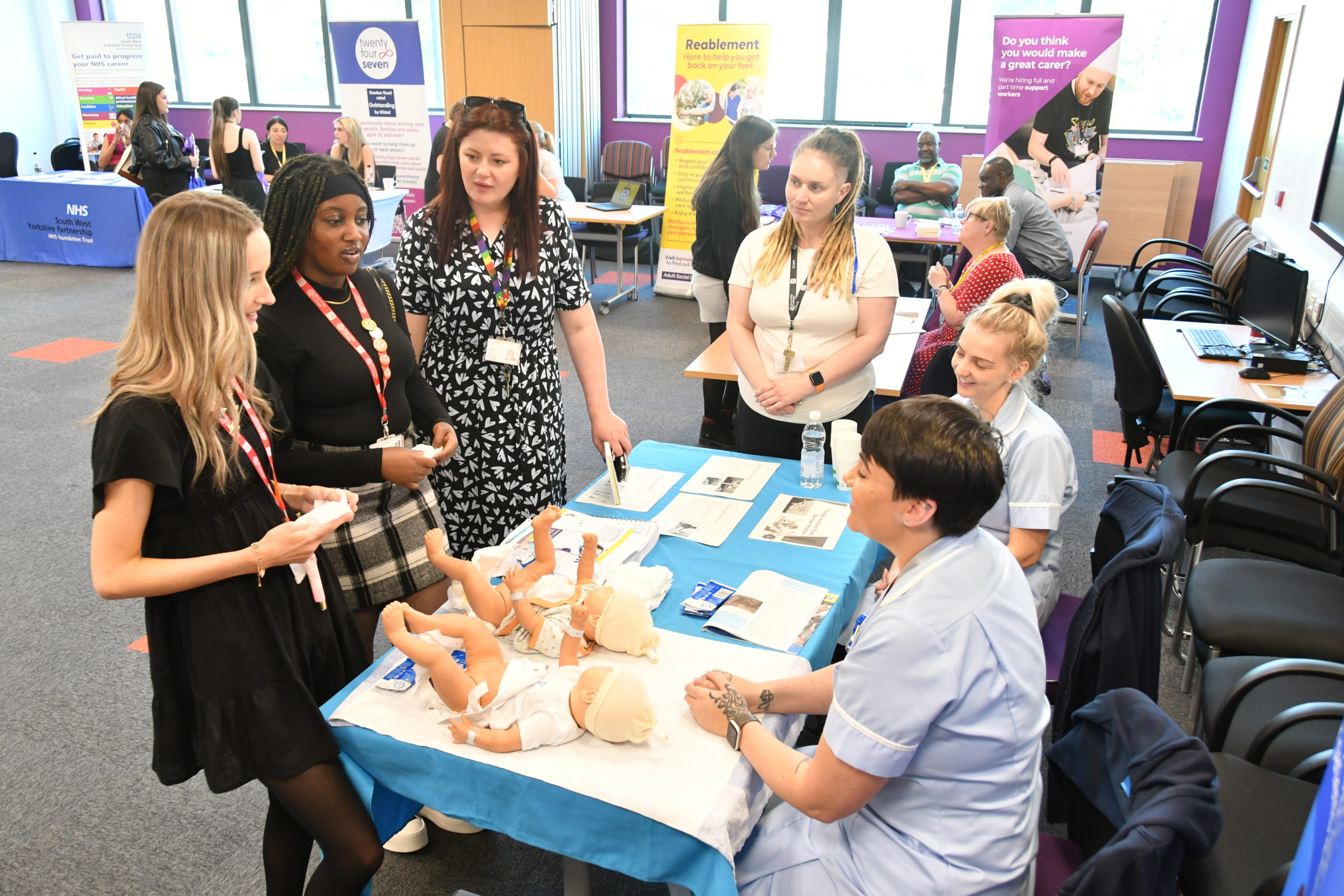Two Health and Social Care students with Barnsley College staff and Midwives from Barnsley Hospital.