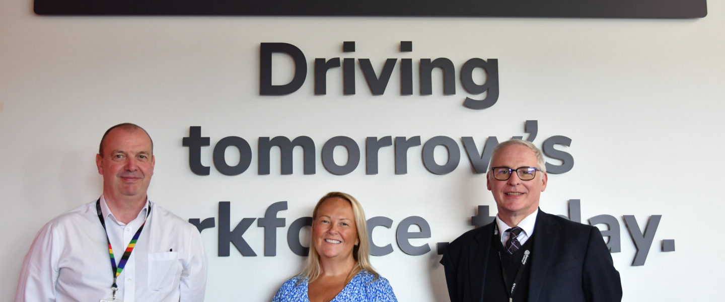 Three people stood in front of a white wall with Car Supermarket logo and the words "Driving tomorrow's workforce today."