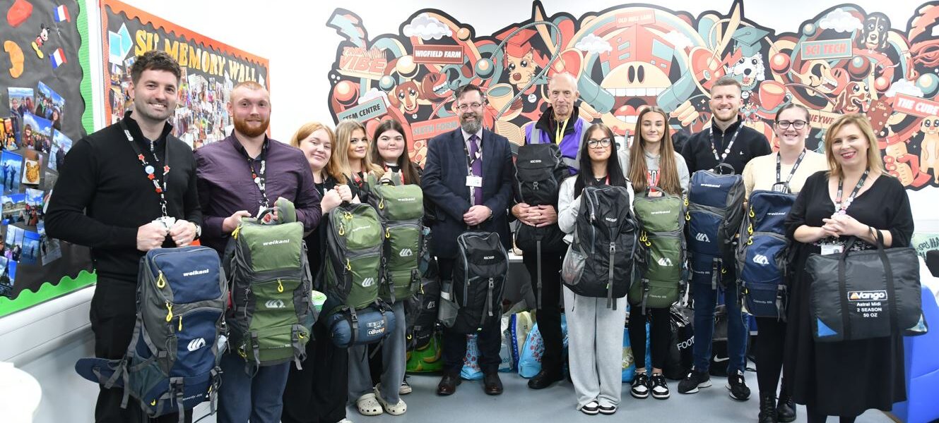 Barnsley College staff and students with Peter Mulrooney (sixth from right) and some of the rucksacks.