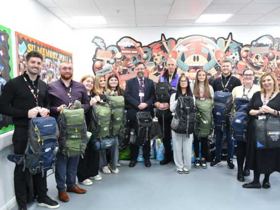 Barnsley College staff and students with Peter Mulrooney (sixth from right) and some of the rucksacks.