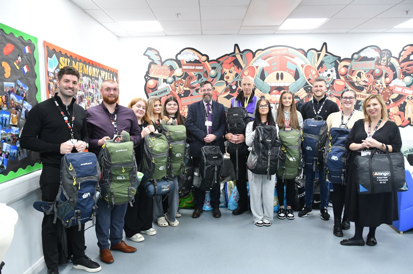 Barnsley College staff and students with Peter Mulrooney (sixth from right) and some of the rucksacks.